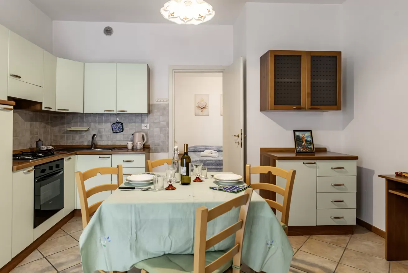 A dining table with chairs sits in a kitchen beside the cooking area.