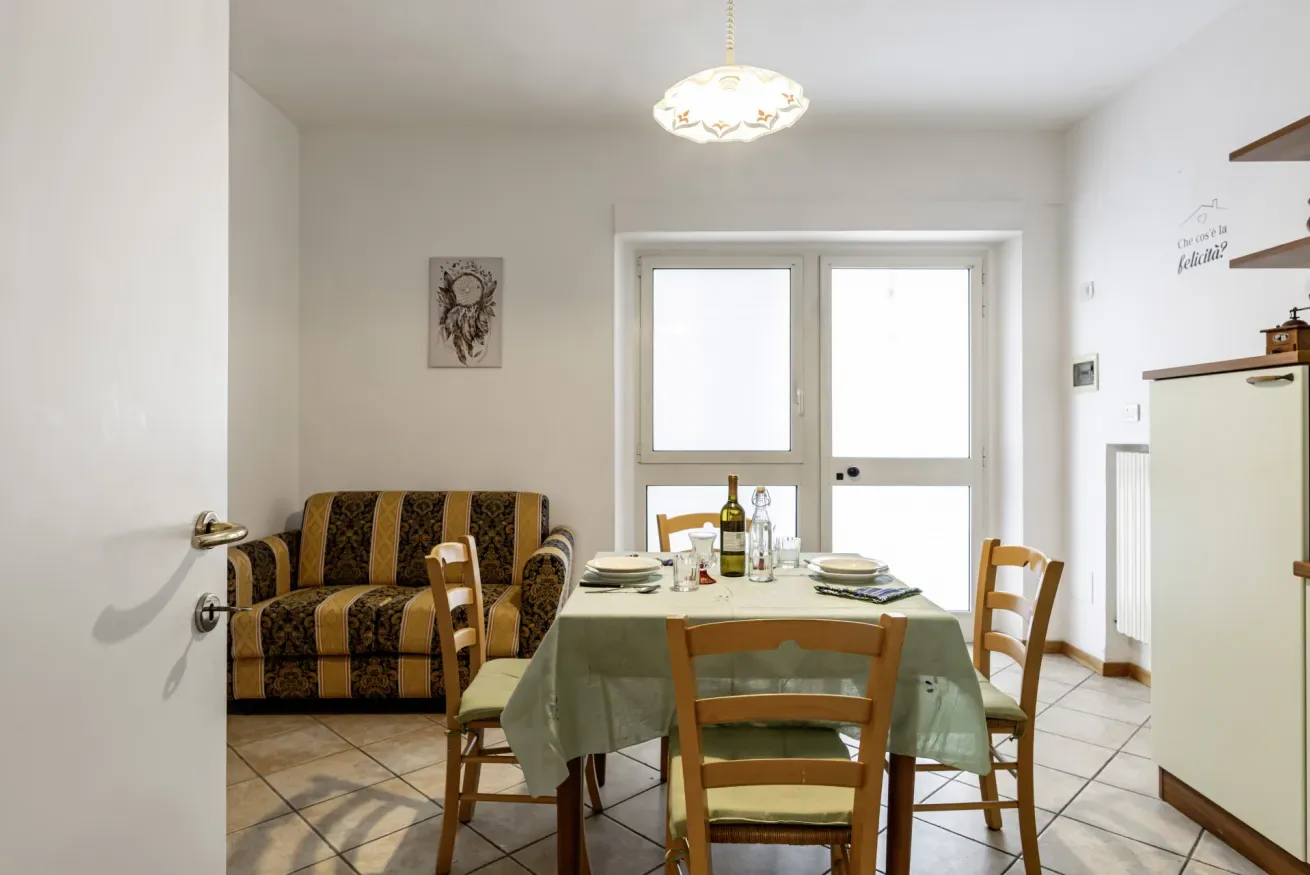 A dining area with a set table beside a patterned sofa.