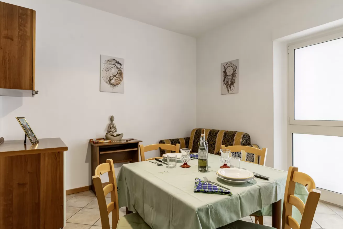 Dining room with a set table and wooden seating.