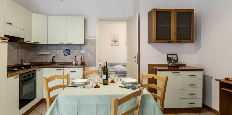 A kitchen and dining area with a table set for a meal.