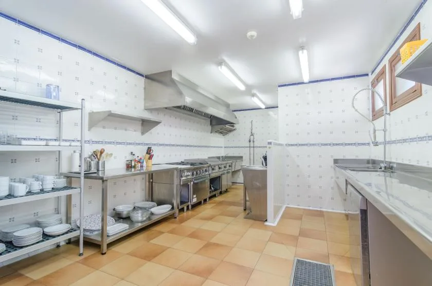 A commercial kitchen with stainless-steel counters and cooking equipment.