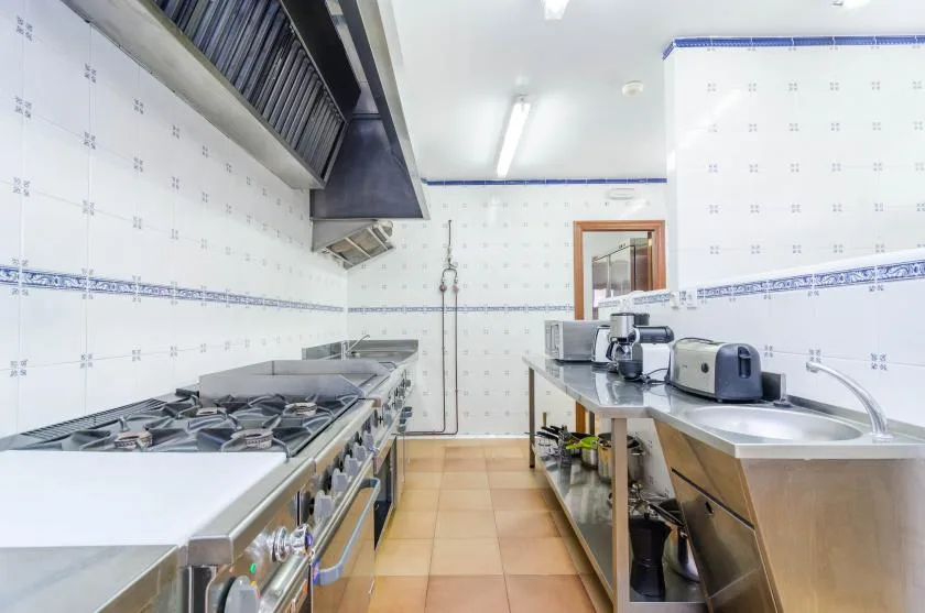 A tiled kitchen with a gas cooktop, stainless-steel counters, and a sink.