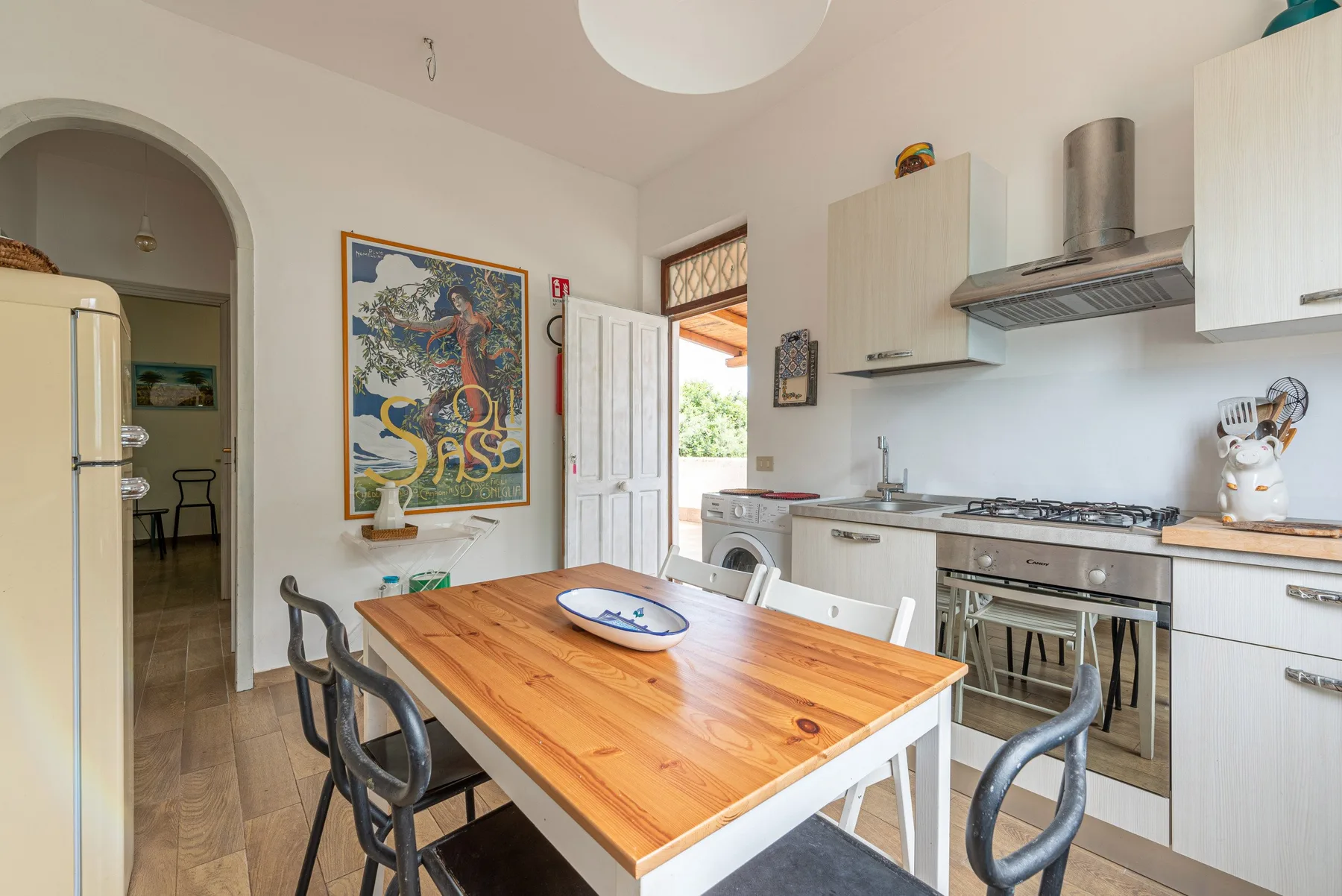 A bright kitchen and dining area with a wooden table and white cabinetry.