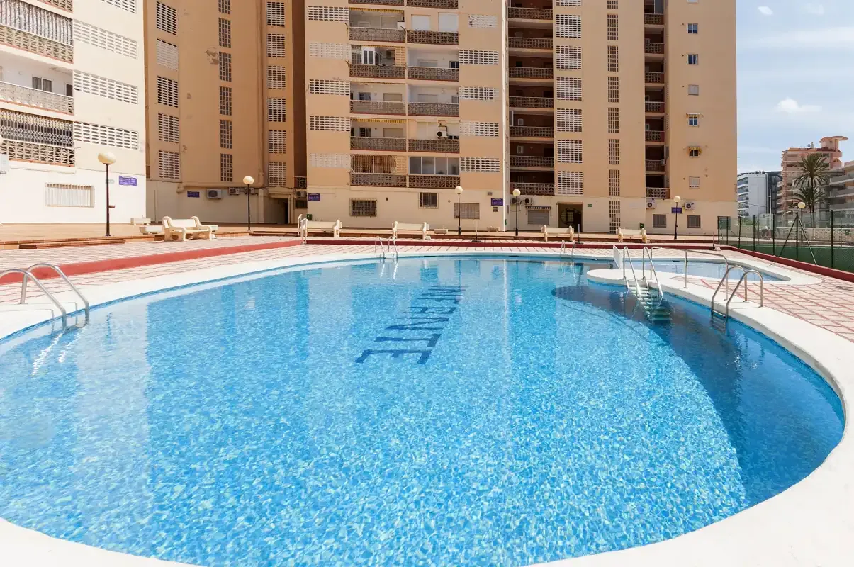 Una piscina está frente a edificios altos de apartamentos.