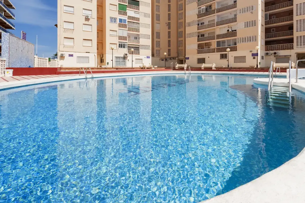 Una piscina está rodeada de edificios de apartamentos.