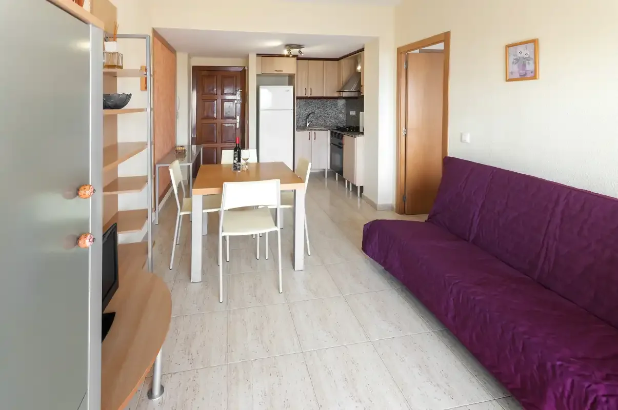 A living and dining area with a purple sofa and table.