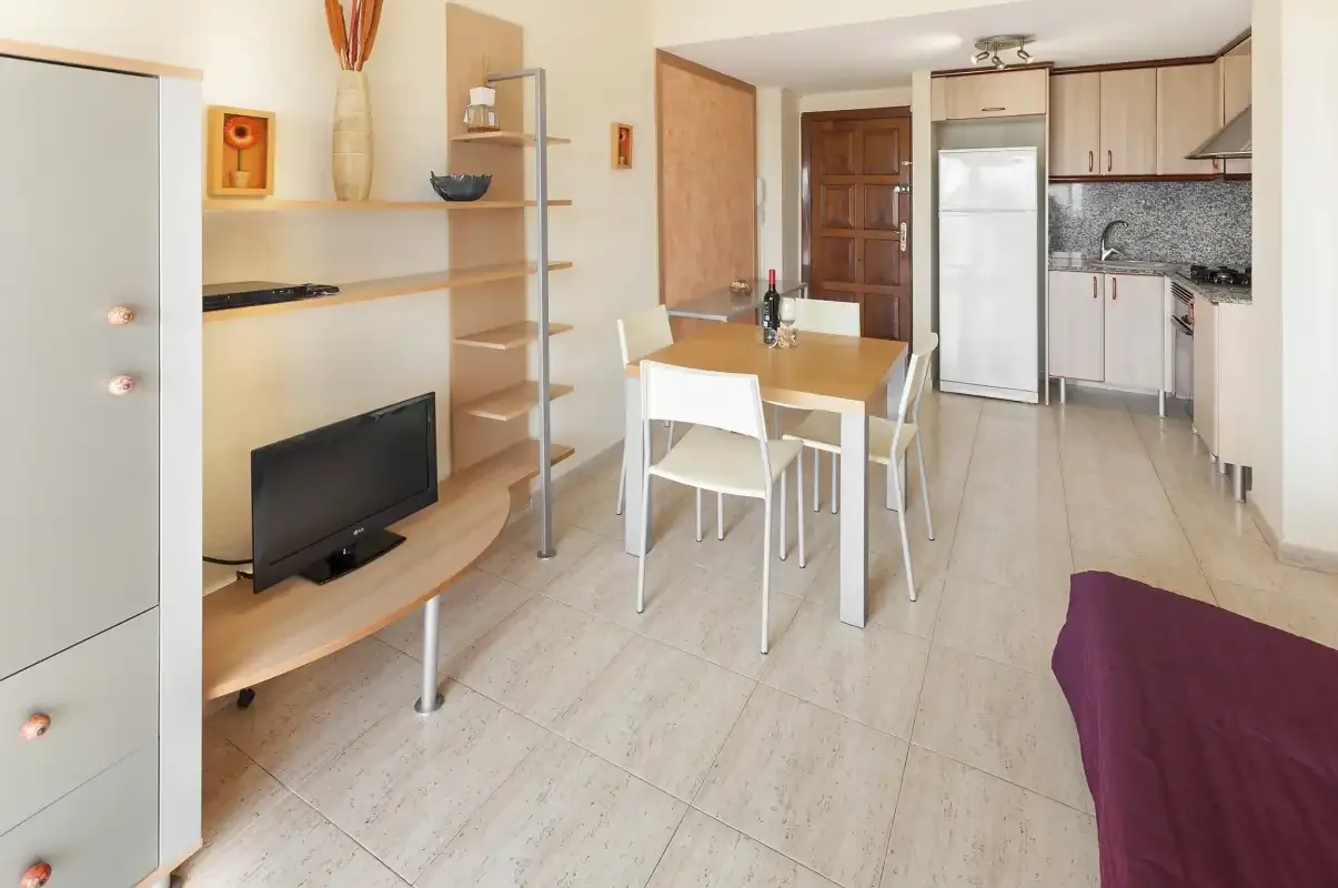 An open-plan living and dining area with a television and a kitchen.