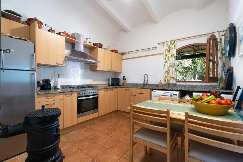 Una cocina luminosa con armarios de madera y una mesa con fruta.
