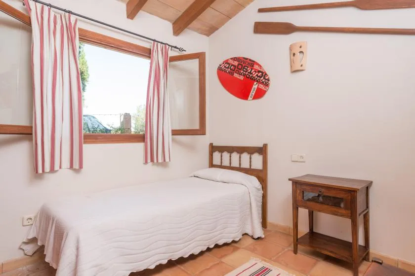 Un dormitorio con una cama junto a una ventana con cortinas a rayas.