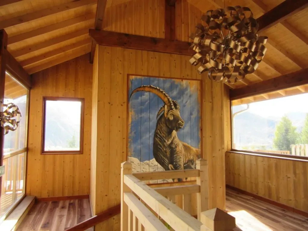 Pasillo de madera del hotel con una obra de arte de una cabra montés