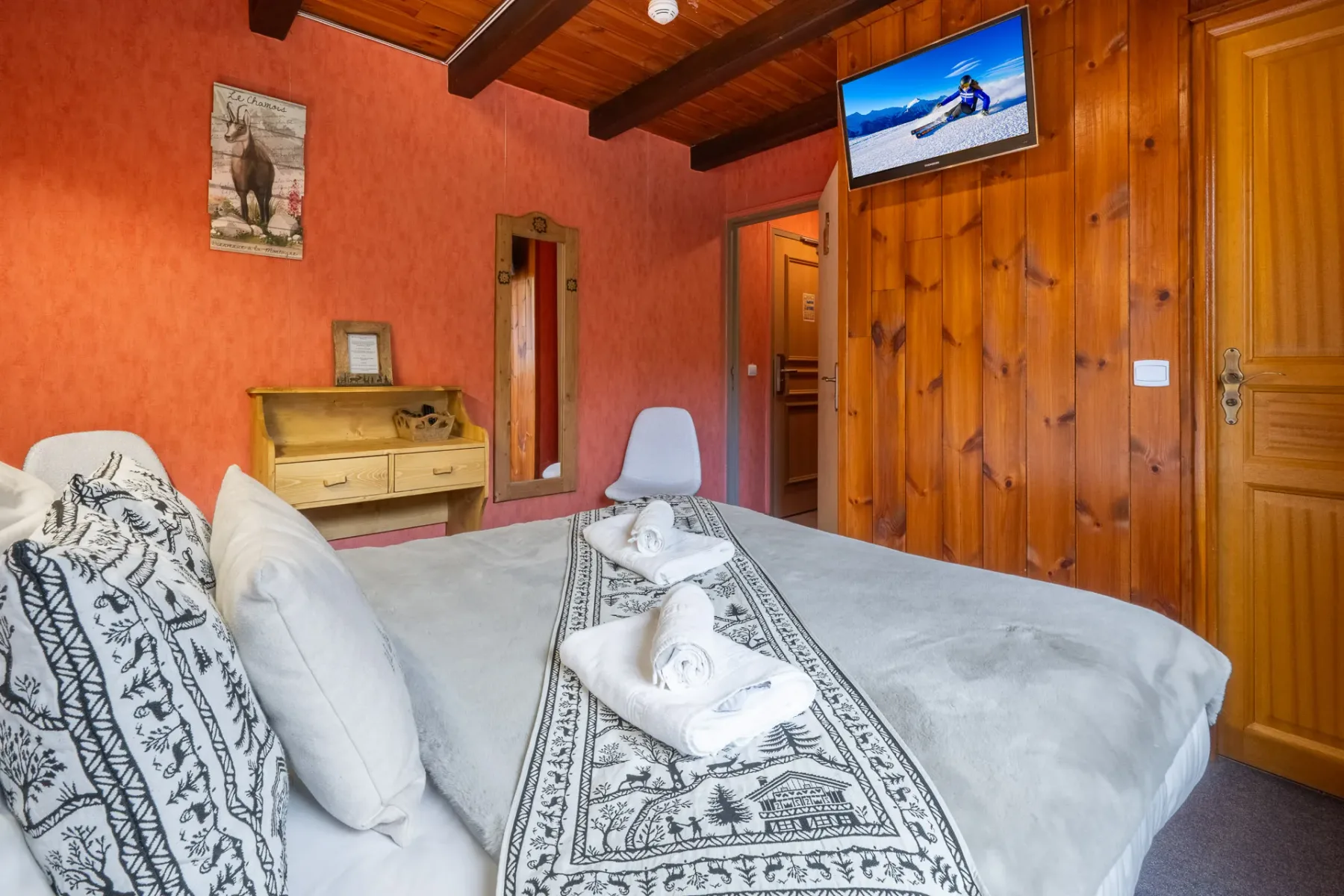 Habitación con cama doble y televisor montado en la pared