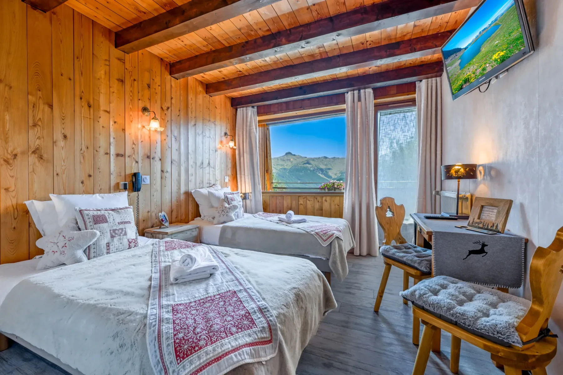 Habitación de huéspedes con dos camas individuales bajo vigas vistas