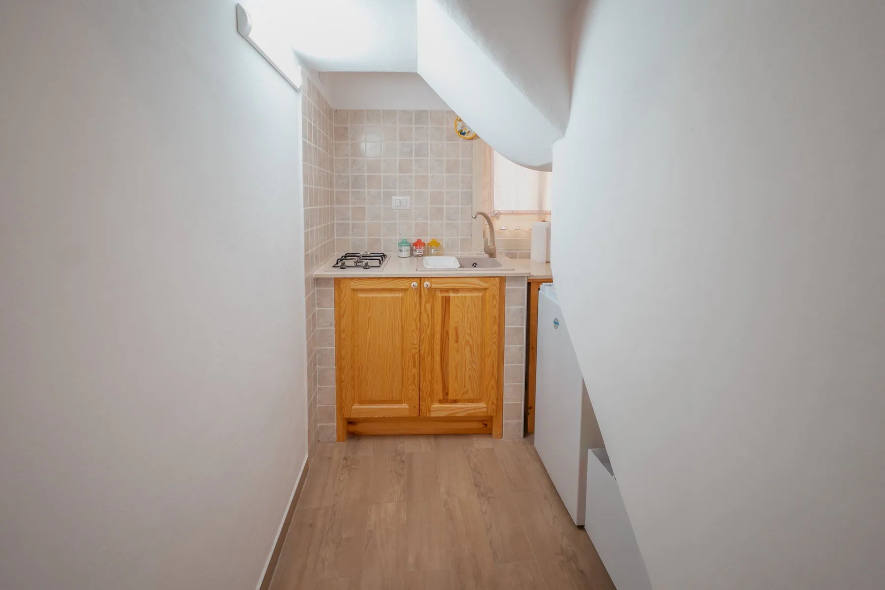 A compact kitchen with wooden cabinets and a tiled backsplash.