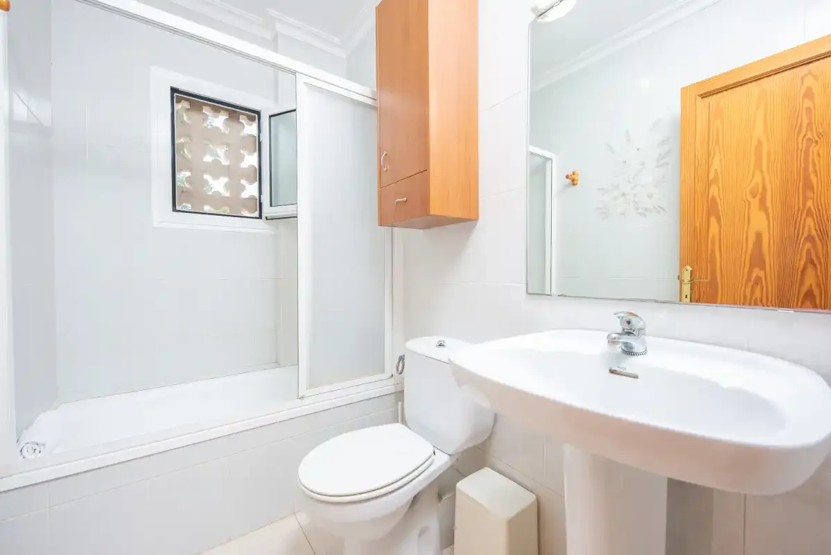 A bathroom with a toilet, sink, and shower.