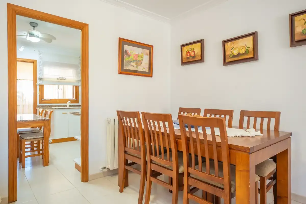 Dining area with a wooden table and chairs beside an open doorway.