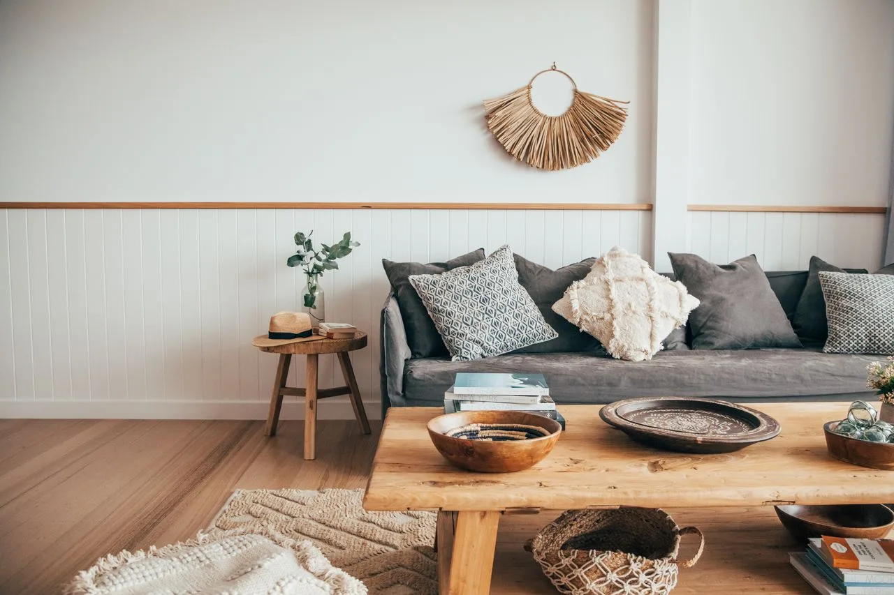 Una sala de estar con un sofá oscuro y una mesa de centro de madera.