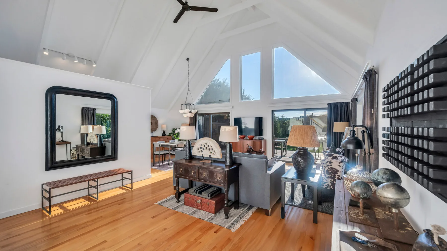 Una sala luminosa con asientos dispuestos bajo grandes ventanas triangulares.
