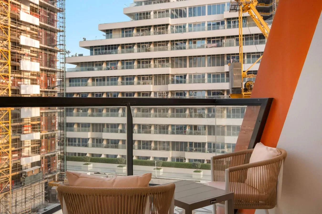 Una zona de estar en el balcón da a edificios cercanos en construcción.
