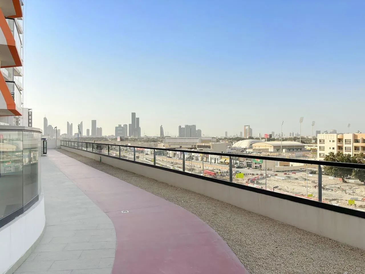 Una terraza en la azotea ofrece vistas del perfil urbano bajo un cielo despejado.