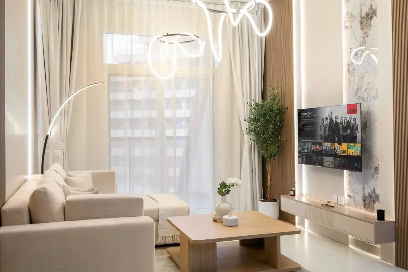 Una sala luminosa con asientos, una mesa de centro y un televisor en la pared.
