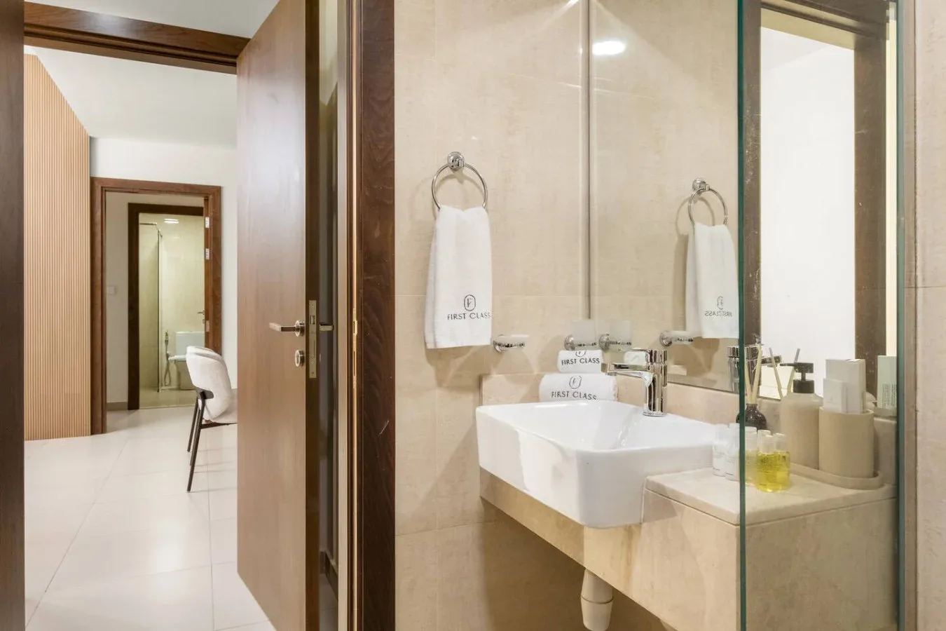 Un lavabo de baño con espejo junto a una puerta abierta.
