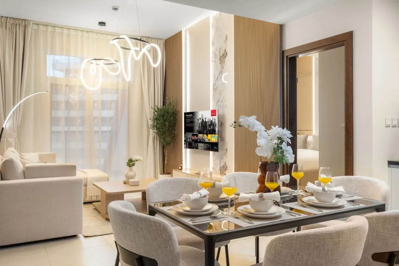 Una luminosa sala de estar y comedor con mesa de vidrio y asientos.
