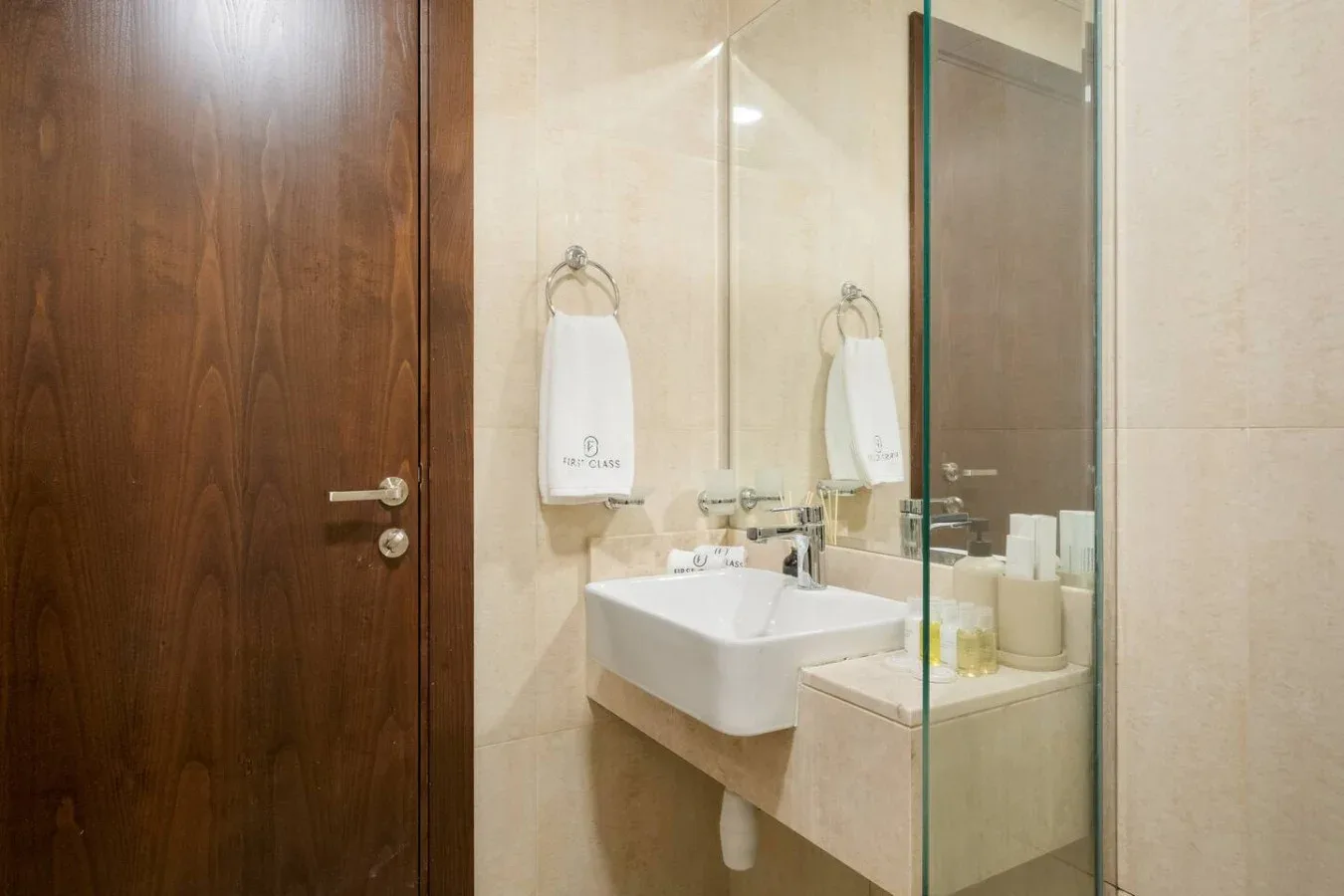 Un baño con un lavabo de pared y un espejo grande.
