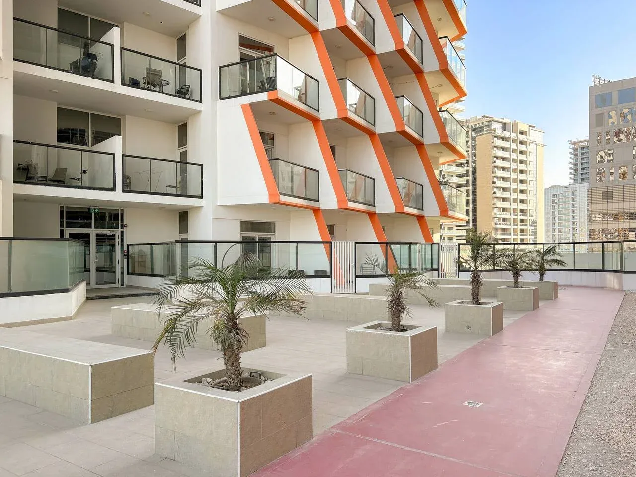 Un edificio de apartamentos moderno da a un patio pavimentado con jardineras.