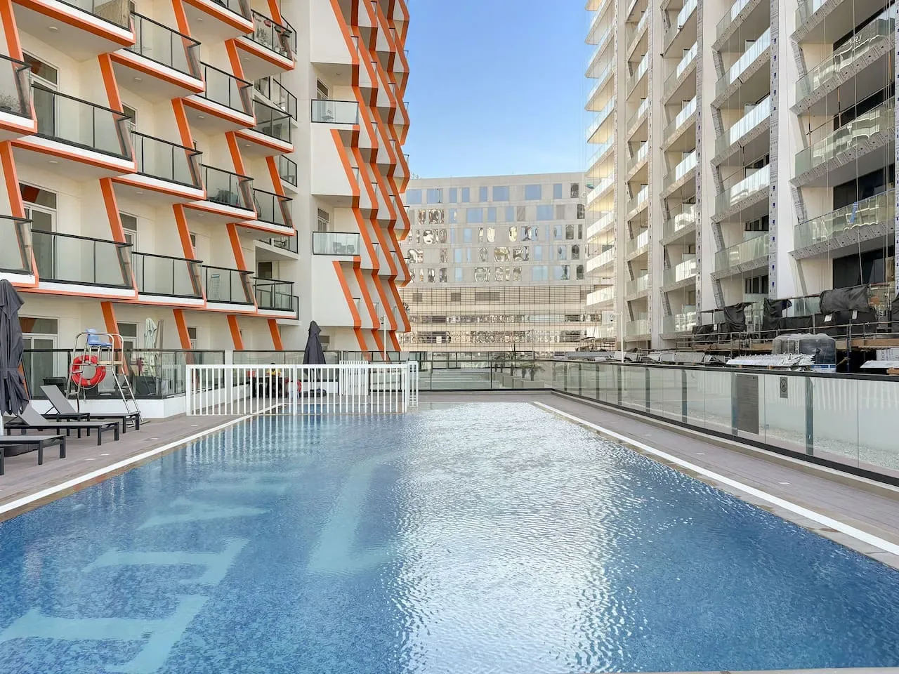 Una piscina está entre edificios de apartamentos modernos.