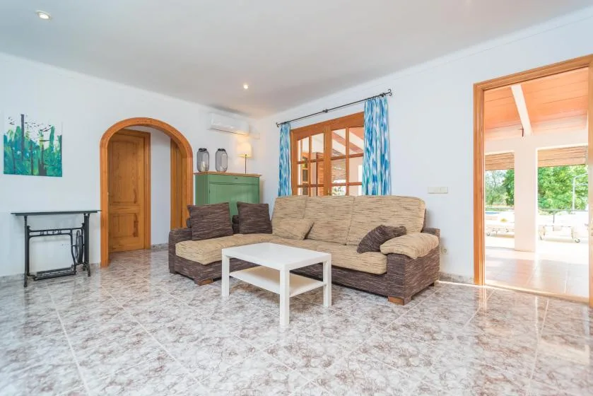 Una sala de estar con un sofá seccional y una mesa de centro blanca.