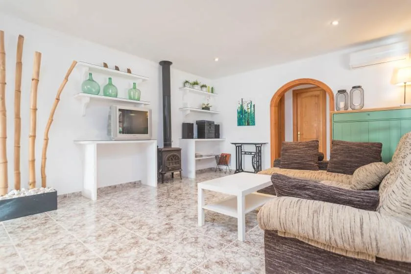 Una sala de estar luminosa con asientos acolchados, una mesa de centro y estantes.