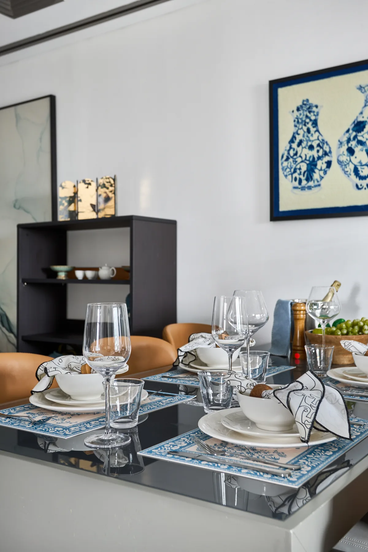 Un comedor con la mesa puesta y cuadros enmarcados en la pared.