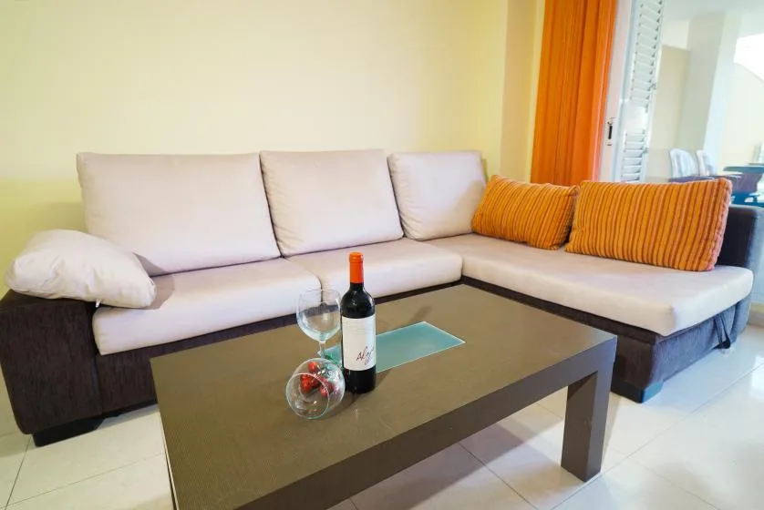 Una sala de estar con un sofá en forma de L y una mesa de centro.