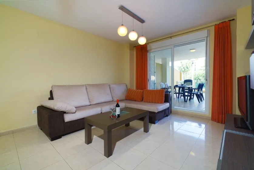 Una sala de estar con asientos y una mesa de centro junto a puertas corredizas de vidrio.