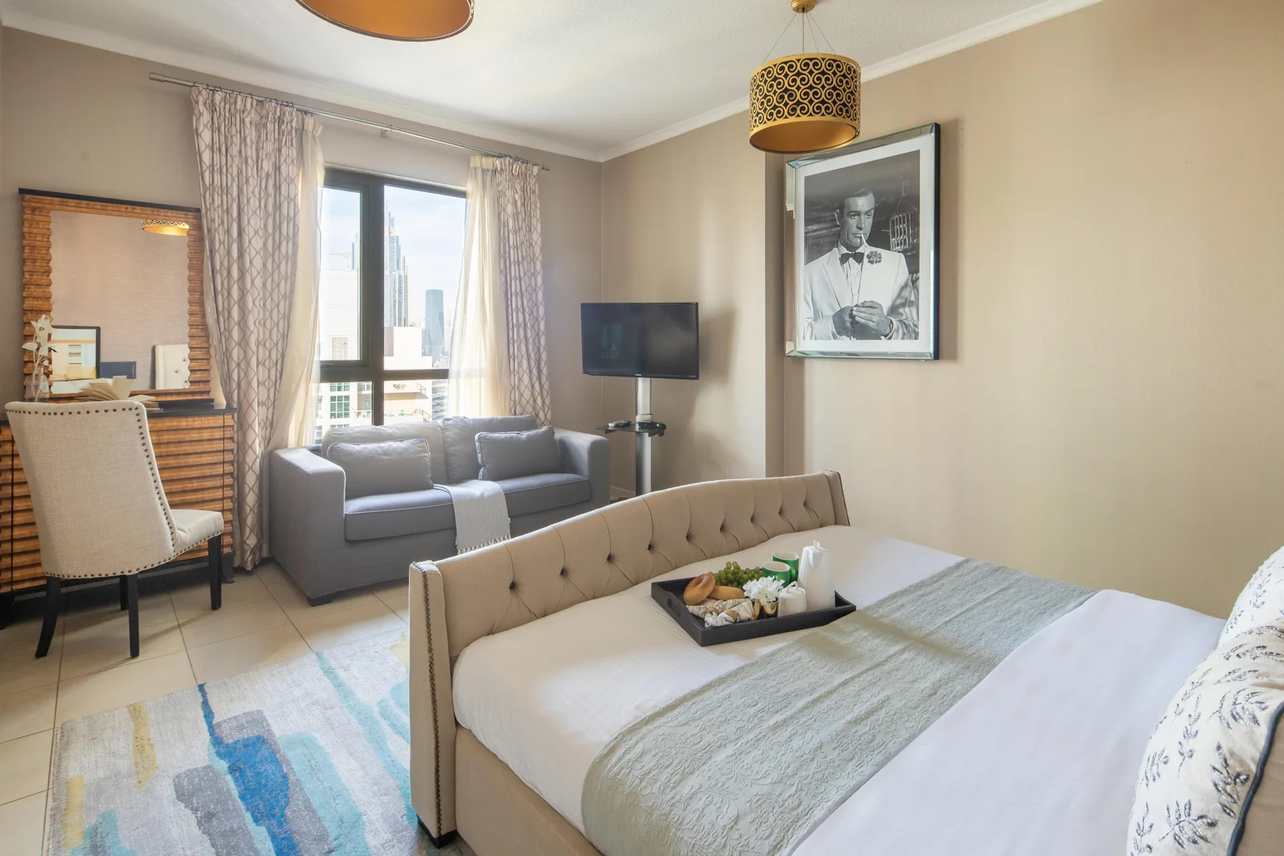 Un dormitorio con cama, zona de estar y ventanas grandes.
