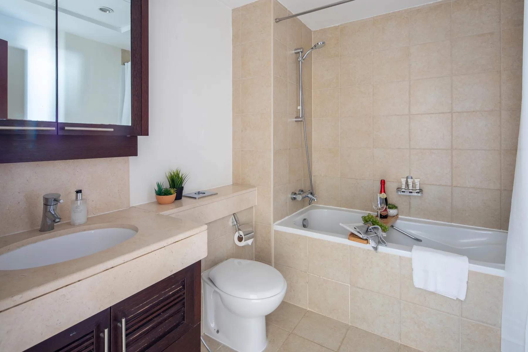 Un baño alicatado con bañera, ducha, lavabo e inodoro.