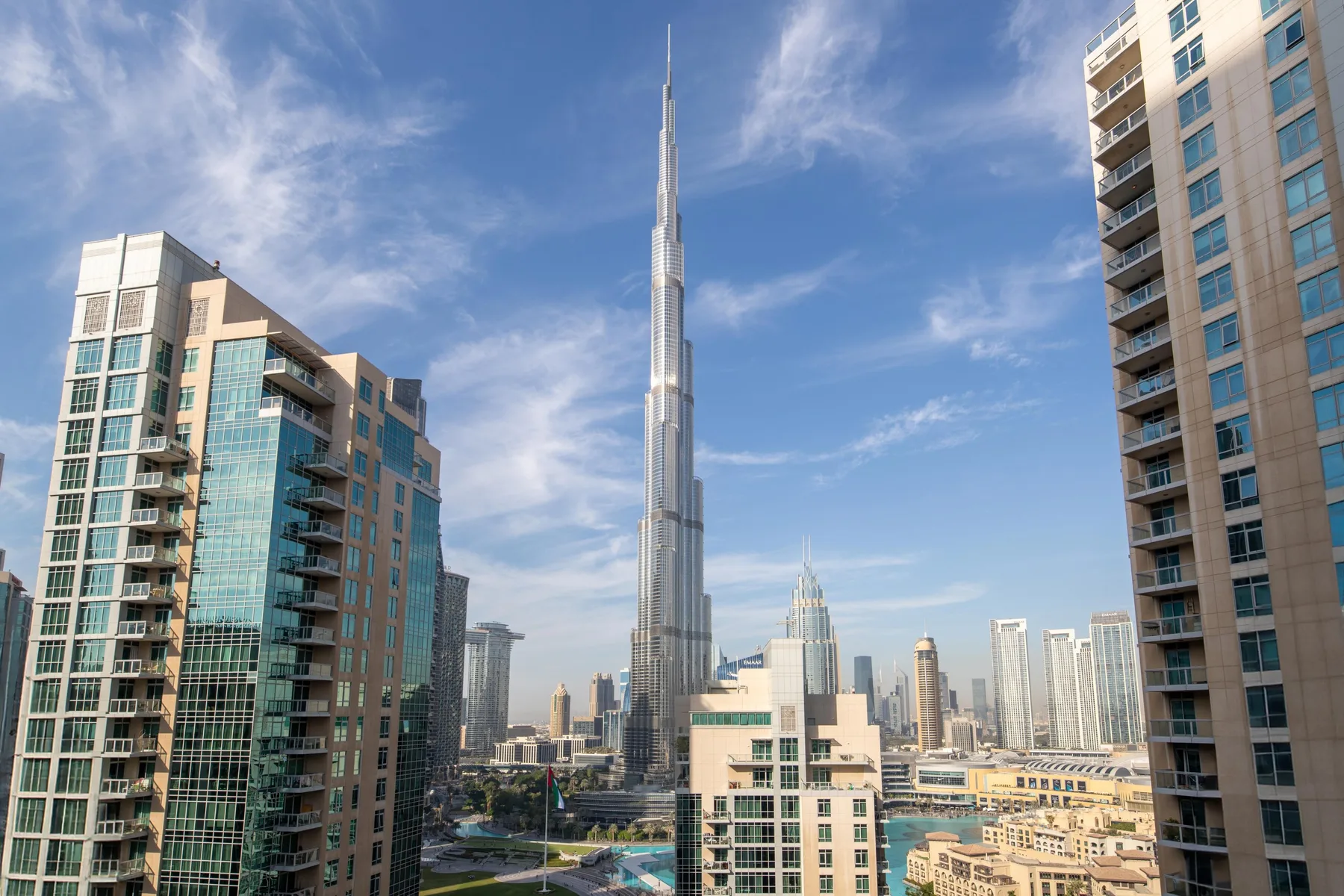 Un horizonte urbano con una torre muy alta en el centro, rodeada de edificios modernos.