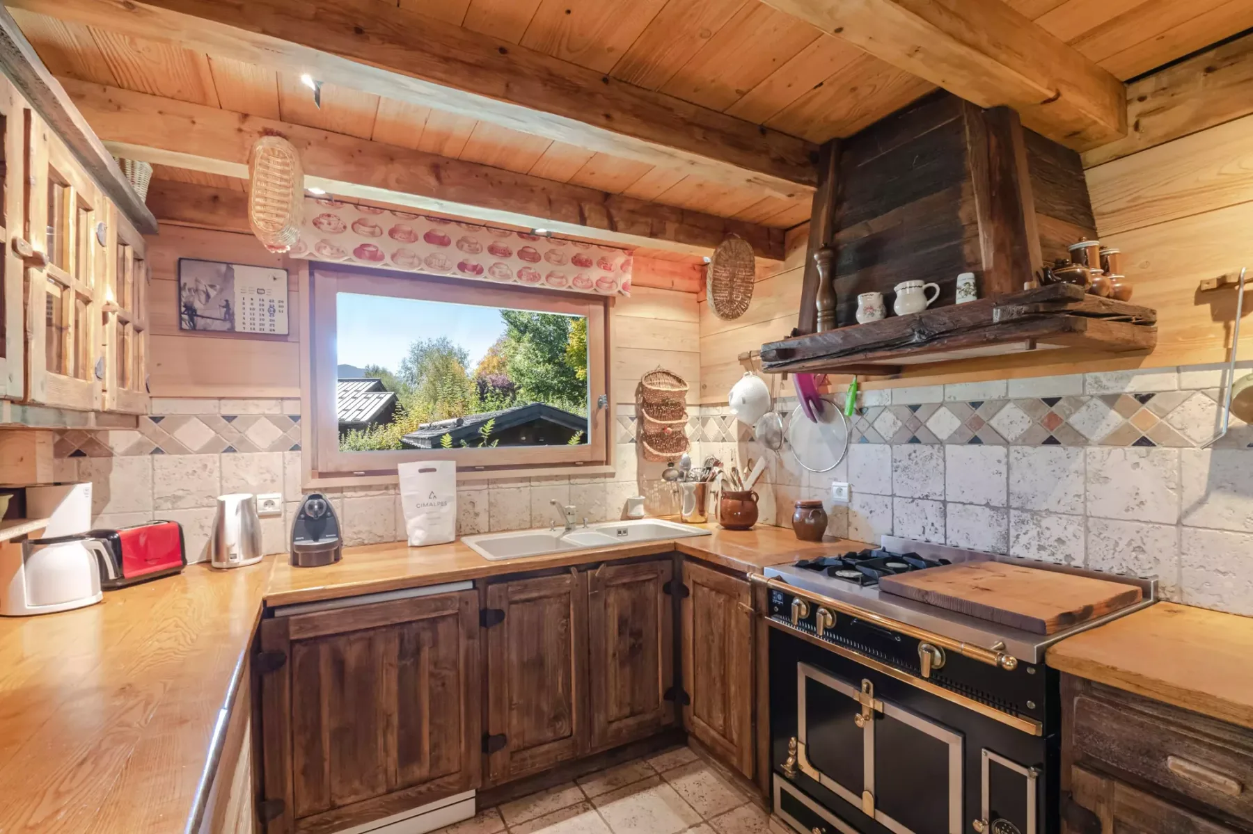 A rustic kitchen with wooden cabinets, tiled walls, and a large range.