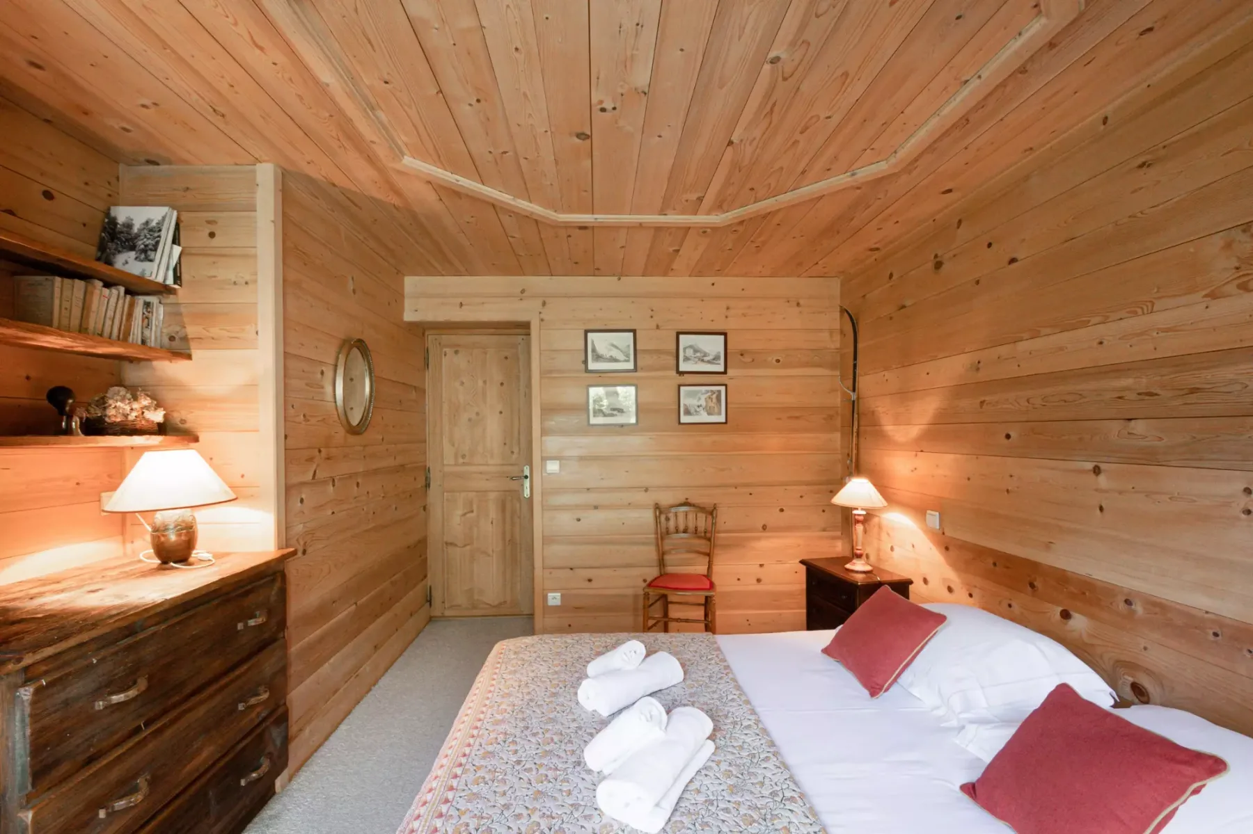 A wood-paneled bedroom with a bed and folded towels.