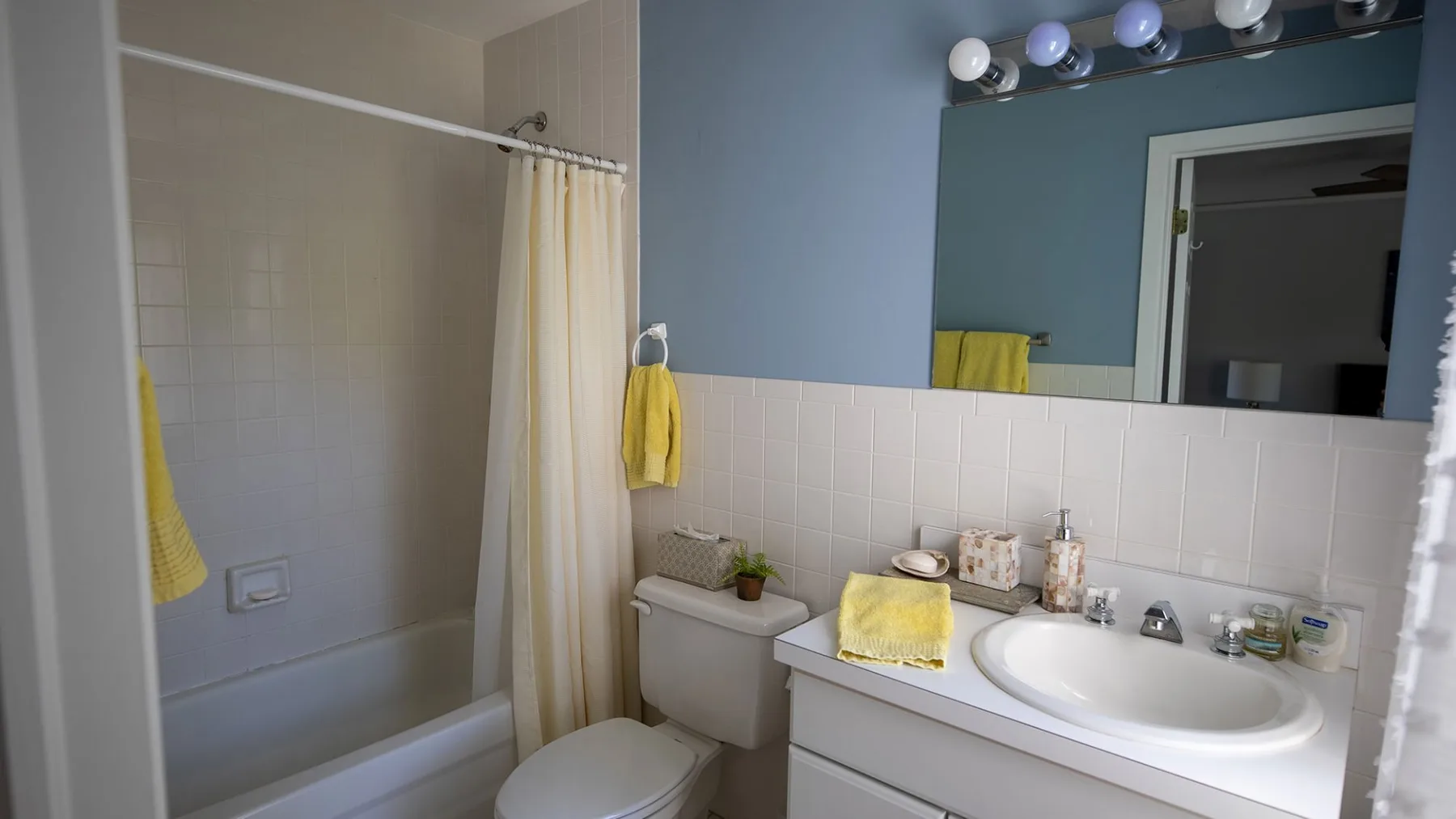 A bathroom with a bathtub, shower curtain, and sink.