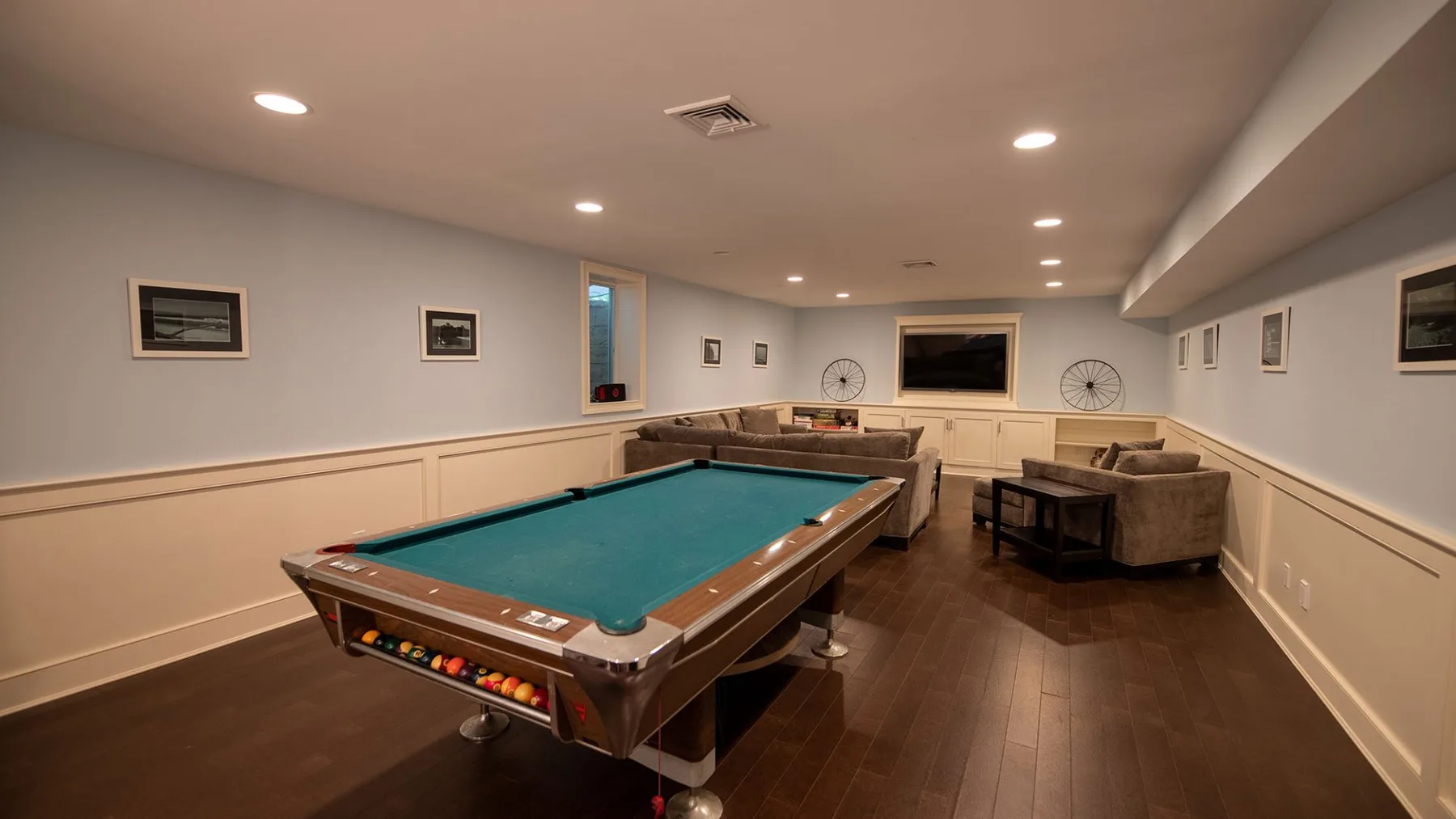 A recreation room with a pool table and seating area.