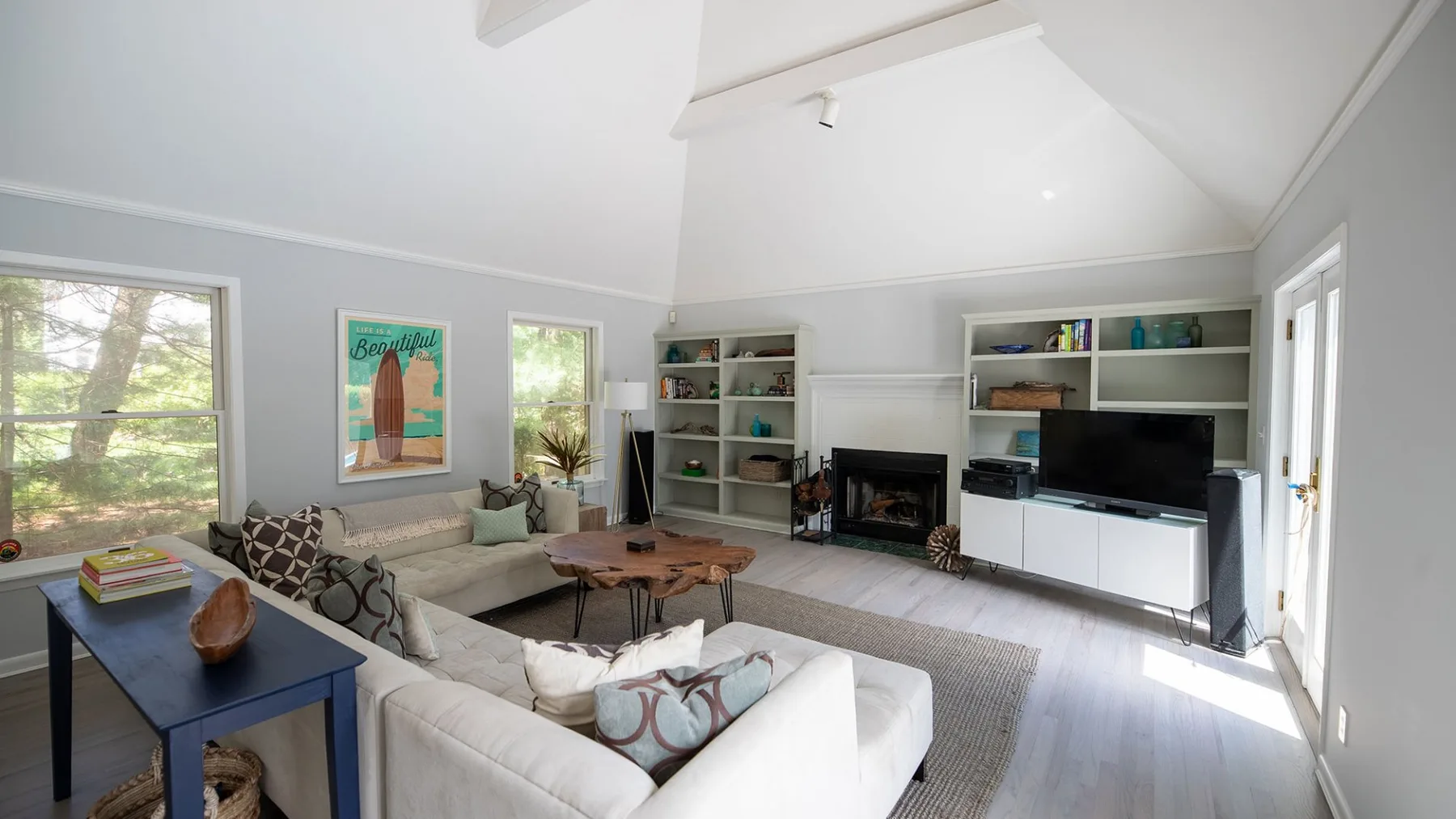 A bright living room with seating, a coffee table, and built-in shelving.