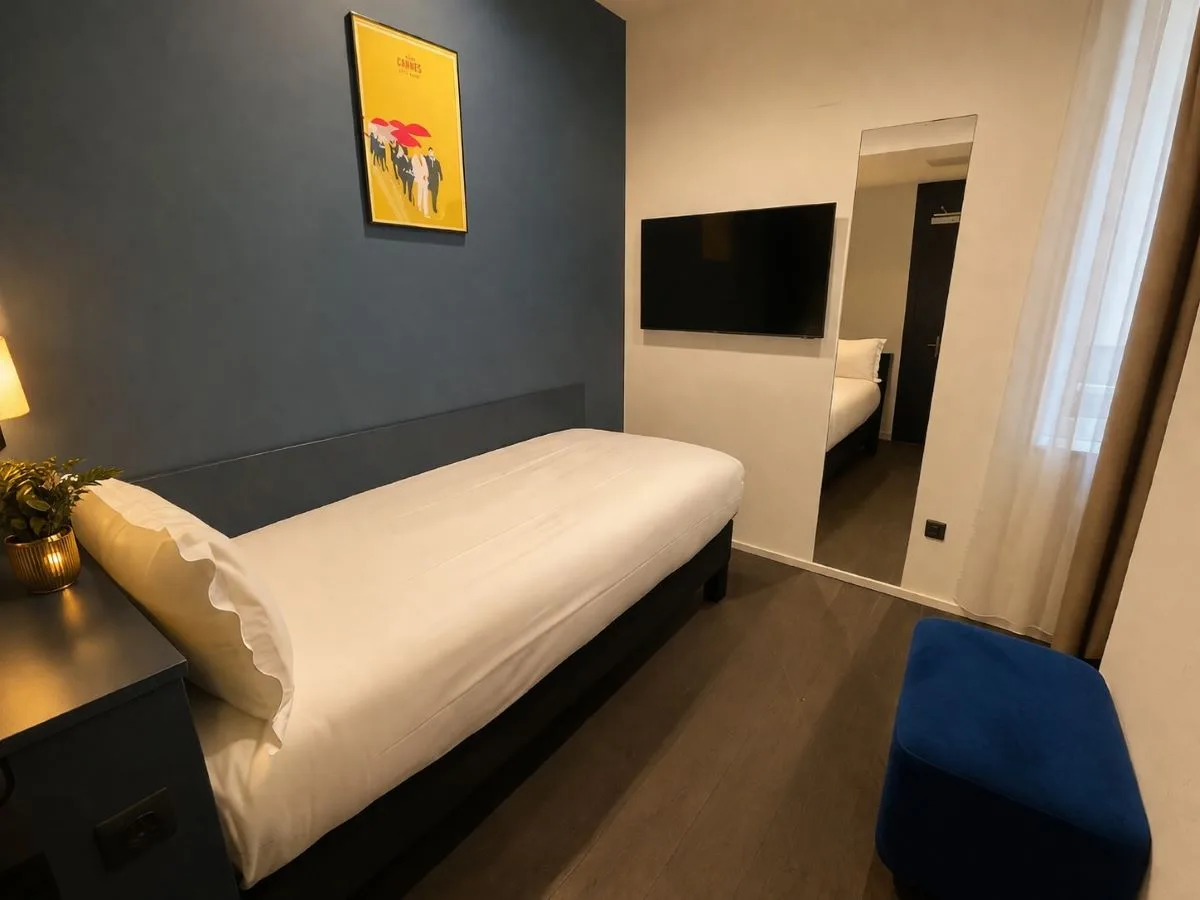 Habitación individual con una cama, cabecero gris pizarra y puf azul marino