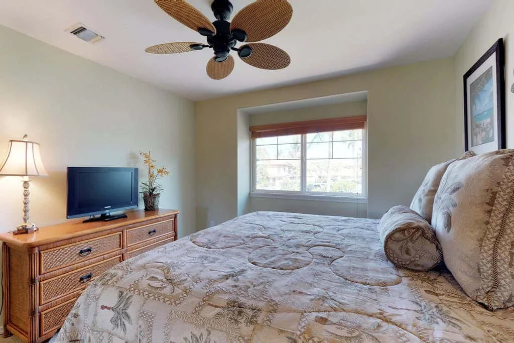 A bedroom with a large bed, a dresser, and a window.