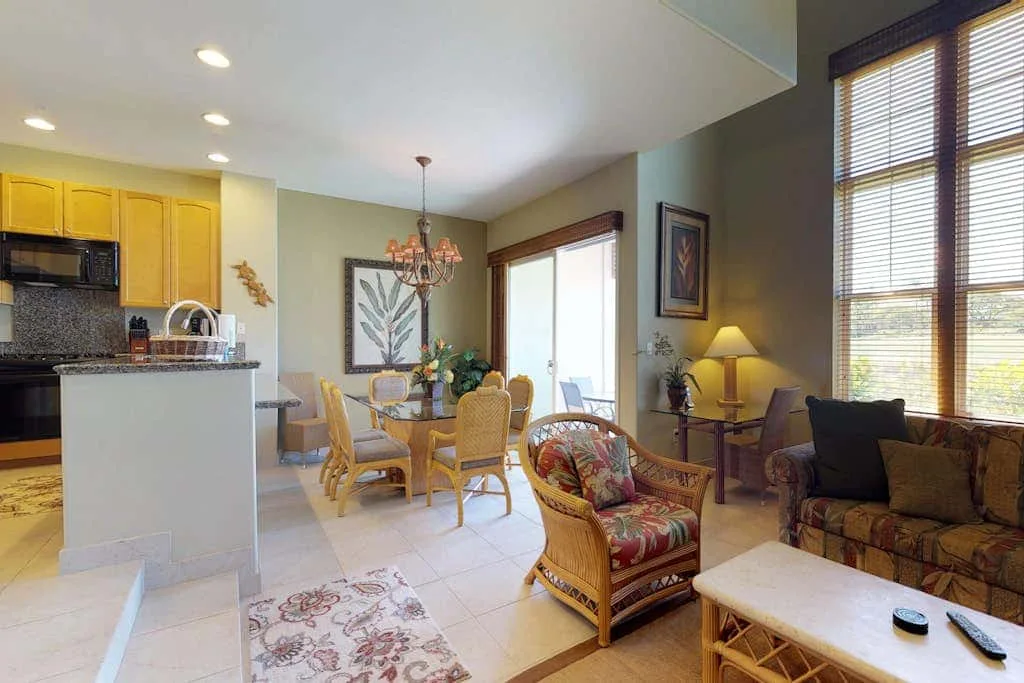 An open-plan living and dining area with a kitchen and wicker seating.
