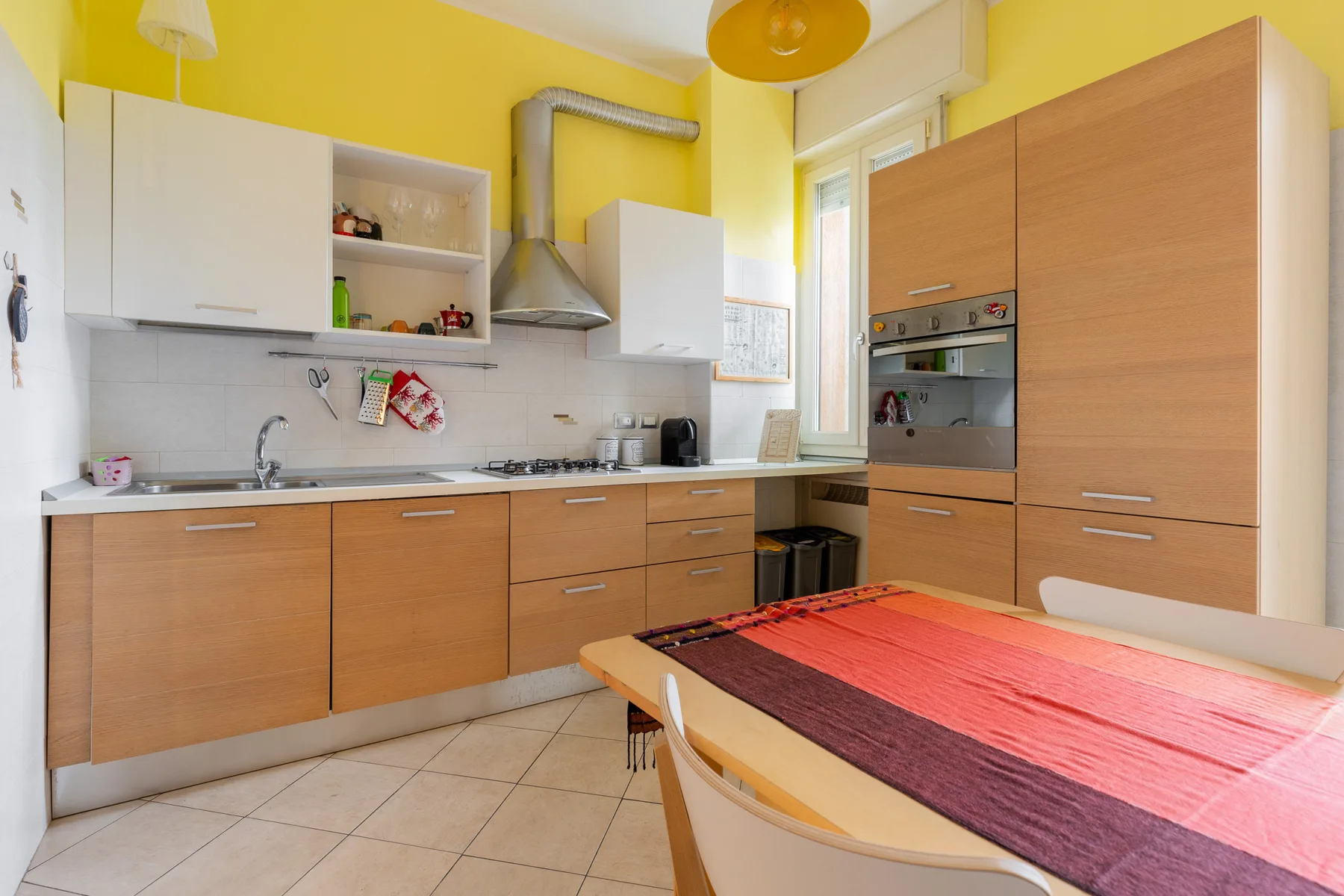 Una cocina luminosa con gabinetes de madera y una mesa de comedor.