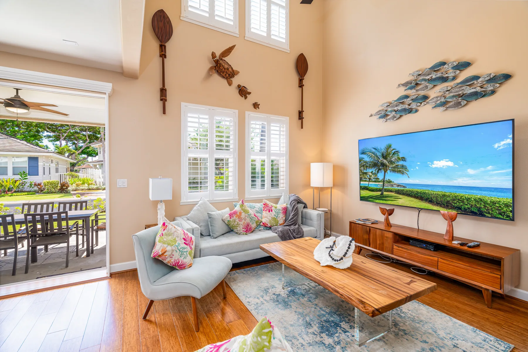 A bright living room with seating, a wooden coffee table, and a television.