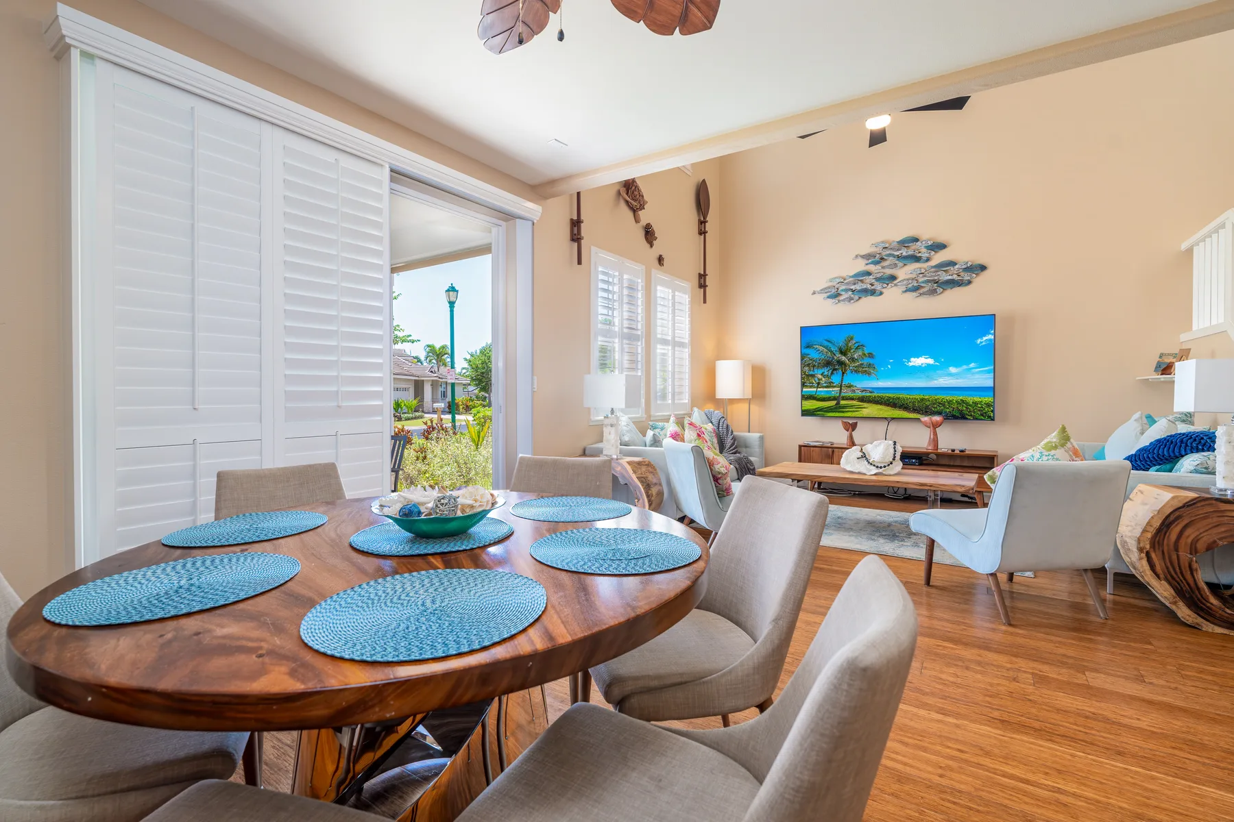 A living and dining area with a round table, seating, and a television.