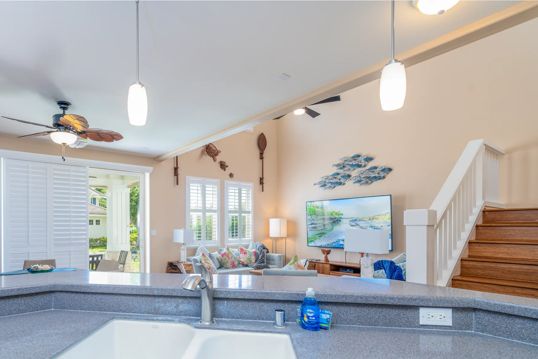 A bright open-plan living area with a kitchen counter and staircase.