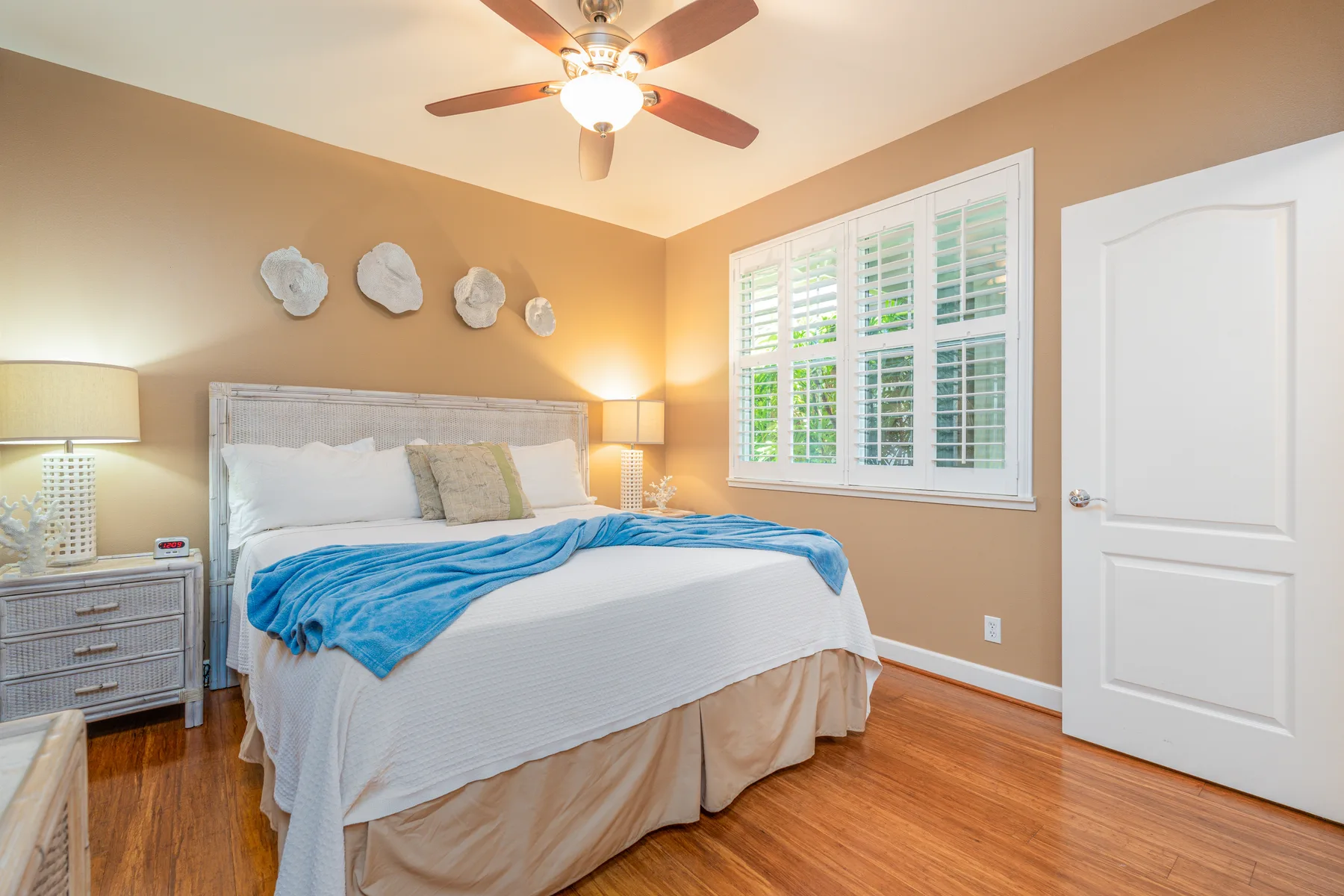 A bedroom with a bed, a window, and a ceiling fan.